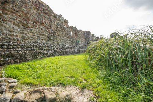 The stone and flint remains of a medieval disused and derelict castle in rural England. A well preserved site of historical interest that is well worth a visit. photo