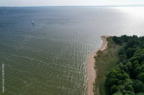 Aerial view with dunes, forest, sea and sail boat in Curonian spit on a sunny day photographed with a drone. The Curonian Spit lagoon is a Unesco world heritage site. Gray Dunes, Dead Dunes.  photo