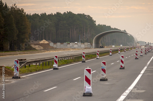 Remont drogi szybkiego ruchu w tle budowa wiaduktu z widoczną częścią konstrukcji na jednym pasie ruchu