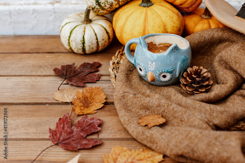 Autumn art composition - hot drink  varied dried leaves  pumpkins on wooden background  cozy autumn