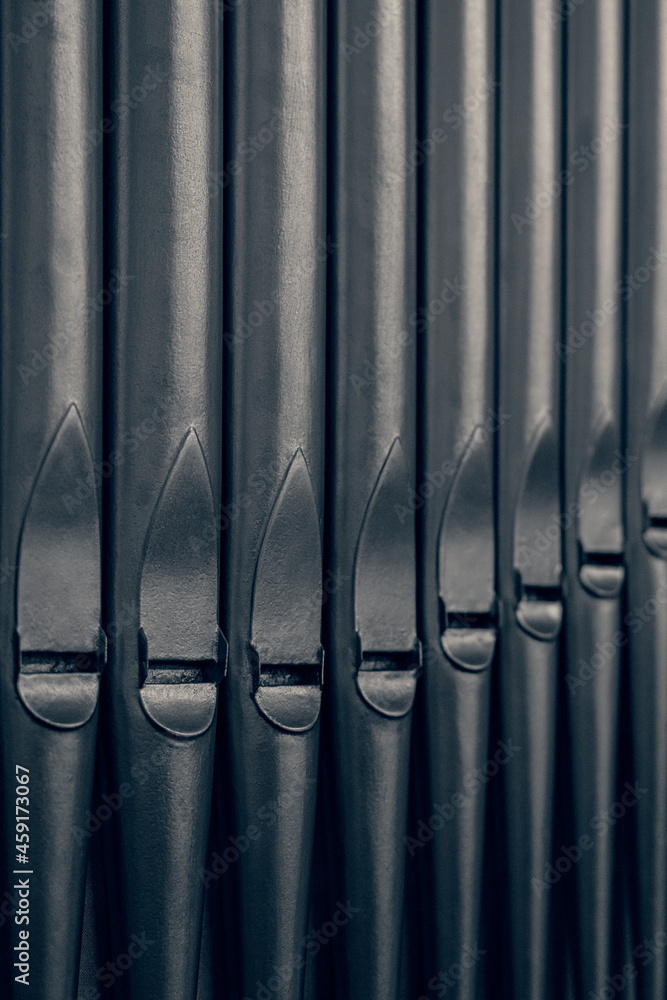 Dark metal organ pipes at an angle. Dark metal organ pipes at an angle.