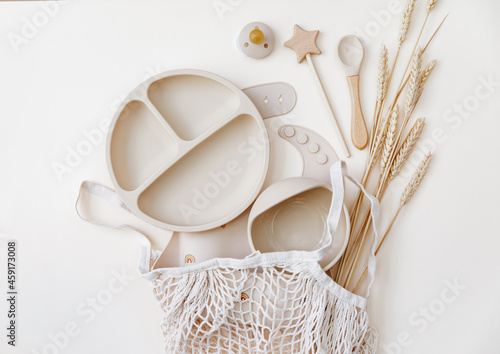 Flat lay beige silicone dishware for baby. Serving kid first feeding concept. copy space, top view photo