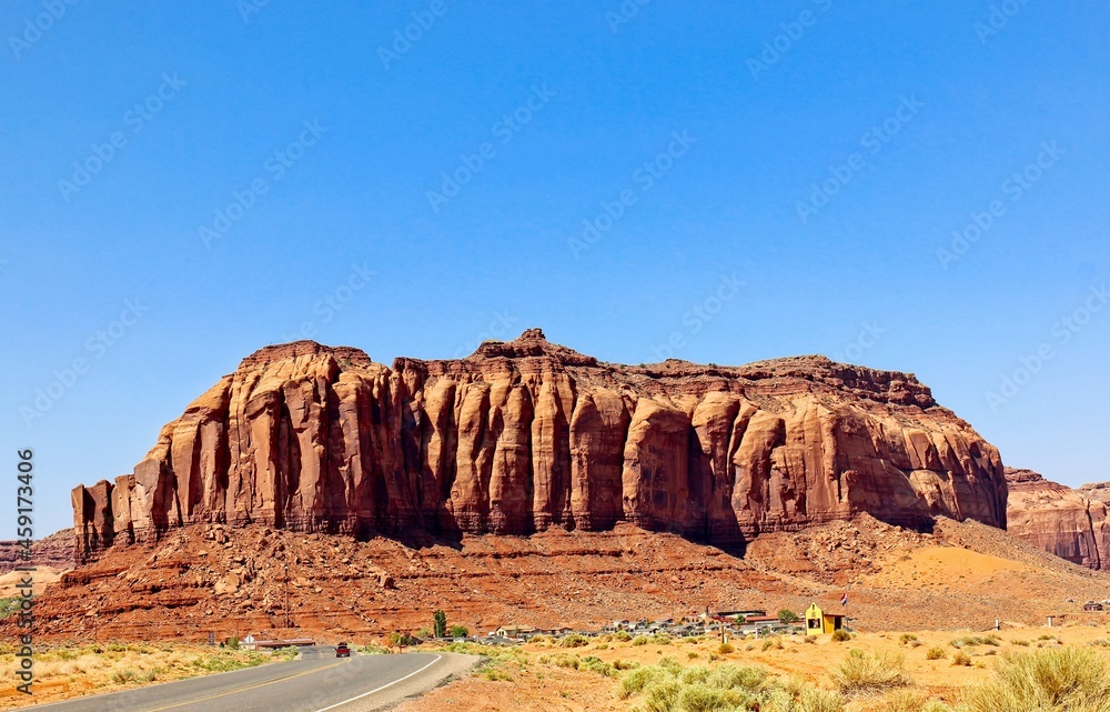 Fototapeta premium Sheer Mountain Overlooking Small Town In Monument Valley, U.S.A.
