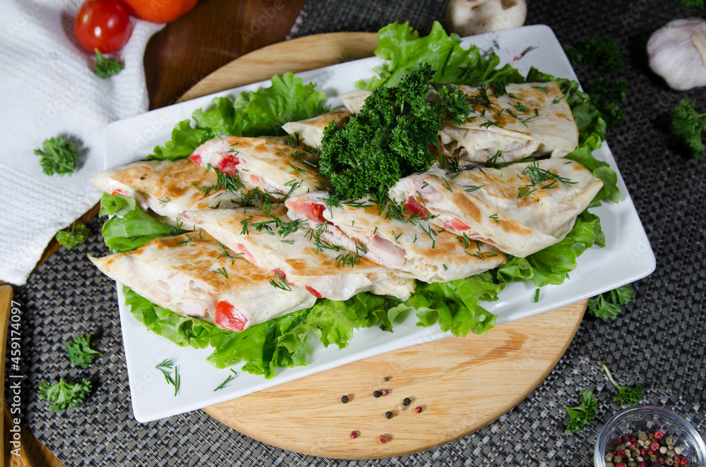 chicken with tomato and cream sauce in pita bread on a white plate decorated with greens, a light healthy snack, a healthy snack, a light meal chicken with tomato and cream sauce in pita bread on a white plate decorated with greens, a light healthy snack, a healthy snack, a light meal