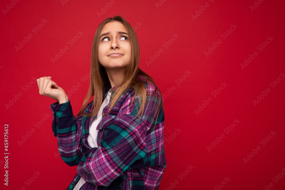 Photo of thoughtful young beautiful dark blonde woman with sincere emotions wearing hipster purple check shirt isolated over red background with copy space and thinking Photo of thoughtful young beautiful dark blonde woman with sincere emotions wearing hipster purple check shirt isolated over red background with copy space and thinking