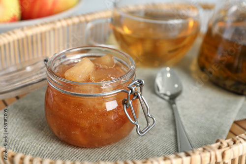 Delicious apple jam in jar on tray, closeup