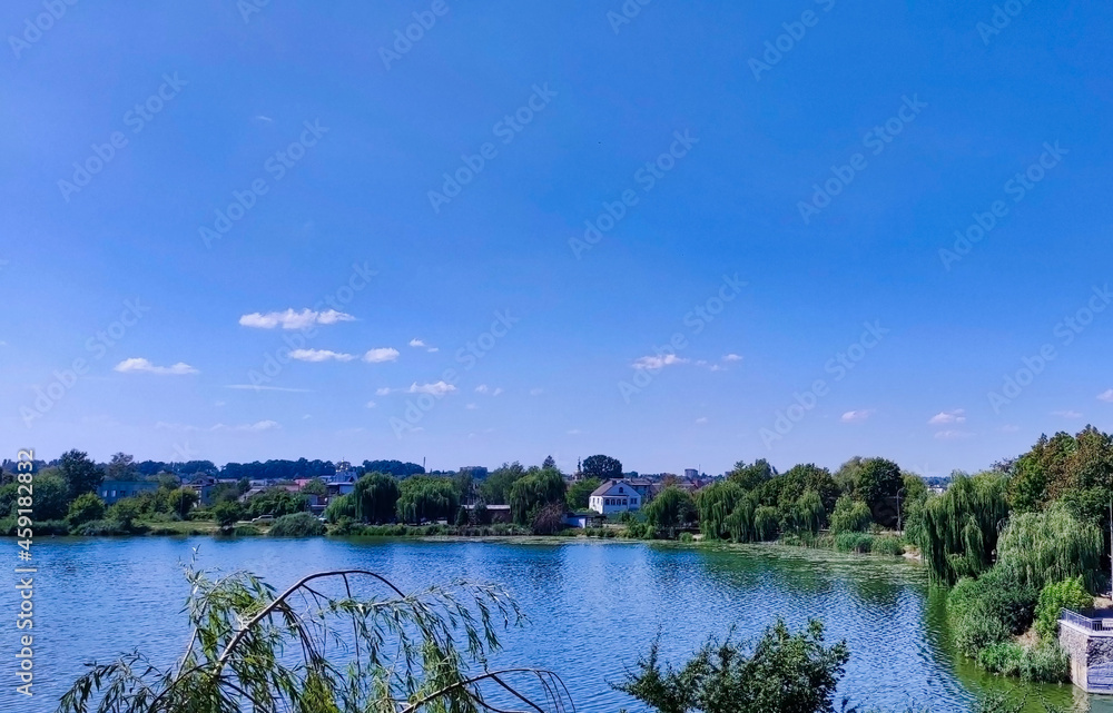 View of the river and lake Basiv Kut in Rivne. Green trees on the shore. Ukraine. Europe View of the river and lake Basiv Kut in Rivne. Green trees on the shore. Ukraine. Europe