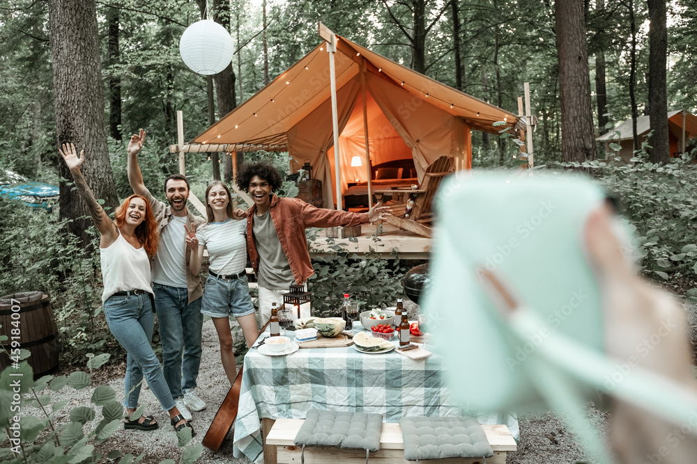 Photographer view of making polaroid photo of friends on picnic, camping glamping life, resting with diverse friends outdoors, enjoying summer camping trip, having fun time in forest, copy space