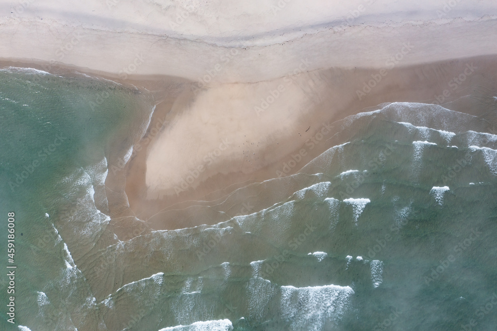 Fototapeta premium The cold, nutrient-filled water of the Atlantic Ocean washes onto a scenic beach in Chatham, Cape Cod, Massachusetts. This beautiful peninsula is a popular vacation destination during summer months.