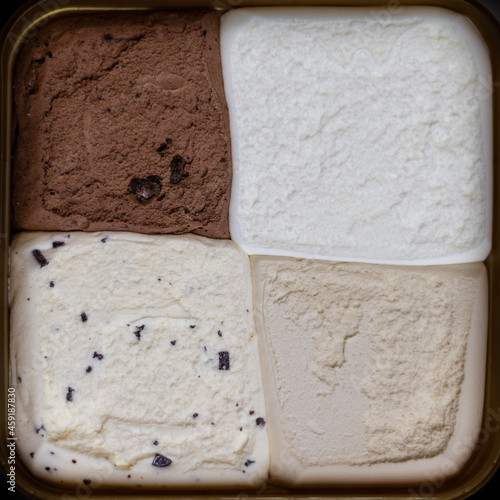 Icecream in the Tub with Lid Newly Opened Shot From Above - Four Flavours