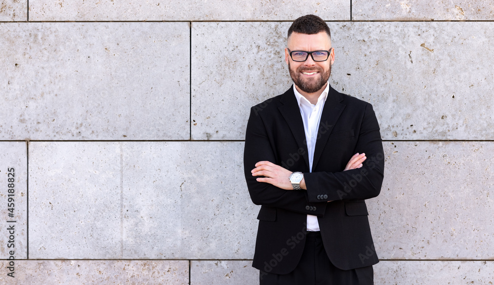 Portrait of confident successful businessman in formal suit with crossed hands smiling at camera Portrait of confident successful businessman in formal suit with crossed hands smiling at camera