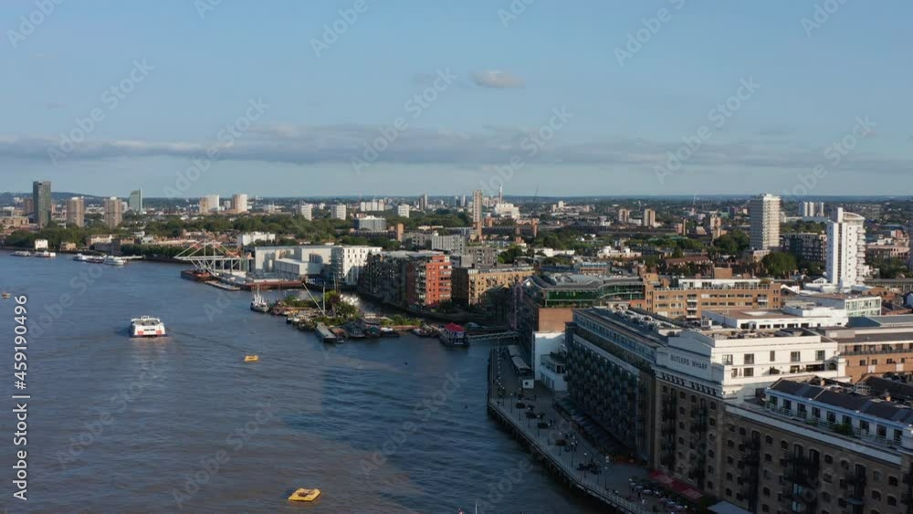 Forwards fly above River Thames along Butlers Wharf Pier. Aerial view of embankment and urban neighbourhood in background. London, UK Forwards fly above River Thames along Butlers Wharf Pier. Aerial view of embankment and urban neighbourhood in background. London, UK