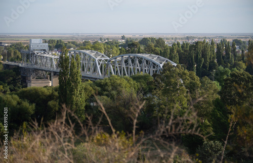 metal train bridge over river traun, viedma argentina. travel explore concept. horizontal photo