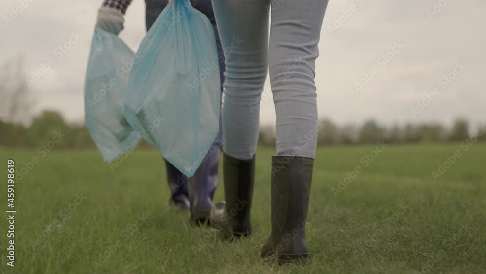 volunteers collect garbage in garbage bags, protect nature from