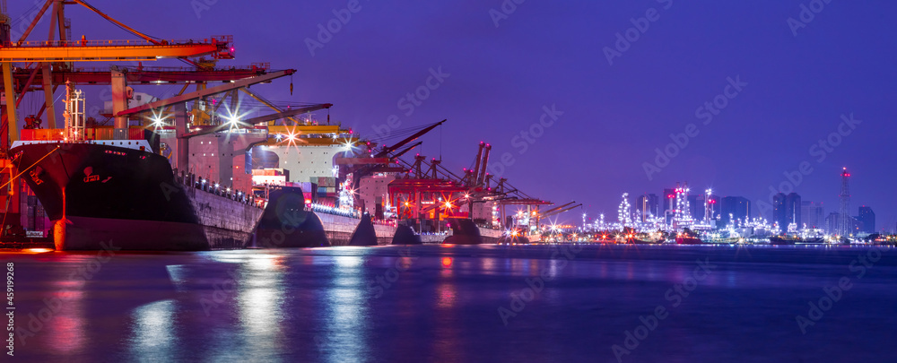Panorama image of Container cargo ship with ports crane bridge loading dock to terminal in harbor against refinery industrial at twilight - obrazy, fototapety, plakaty 