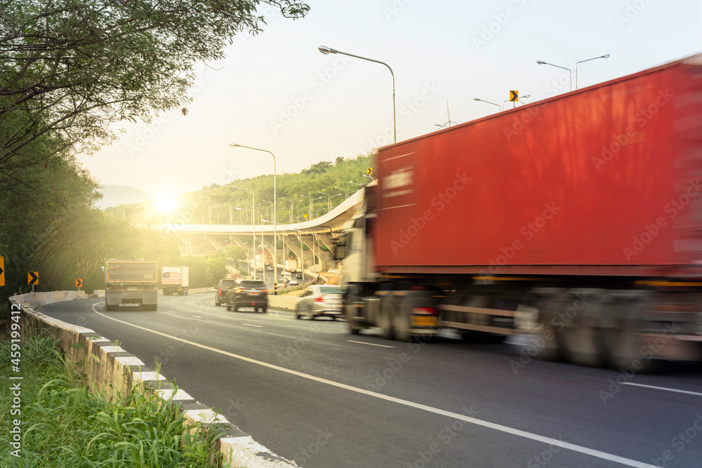 Truck with space for text driving fast on the countryside road with mountain against sunrise