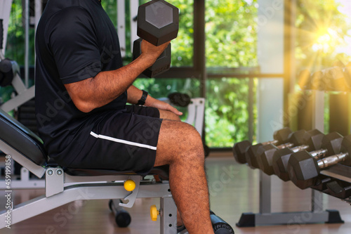 Fitness men workout with dumbbell at the gym in sunrise photo