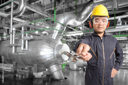 Mechanic holding wrench for working at equipment and pipeline in a modern thermal power plant industrial