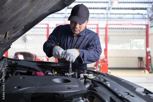 Professional car mechanic working in maintenance repair service station