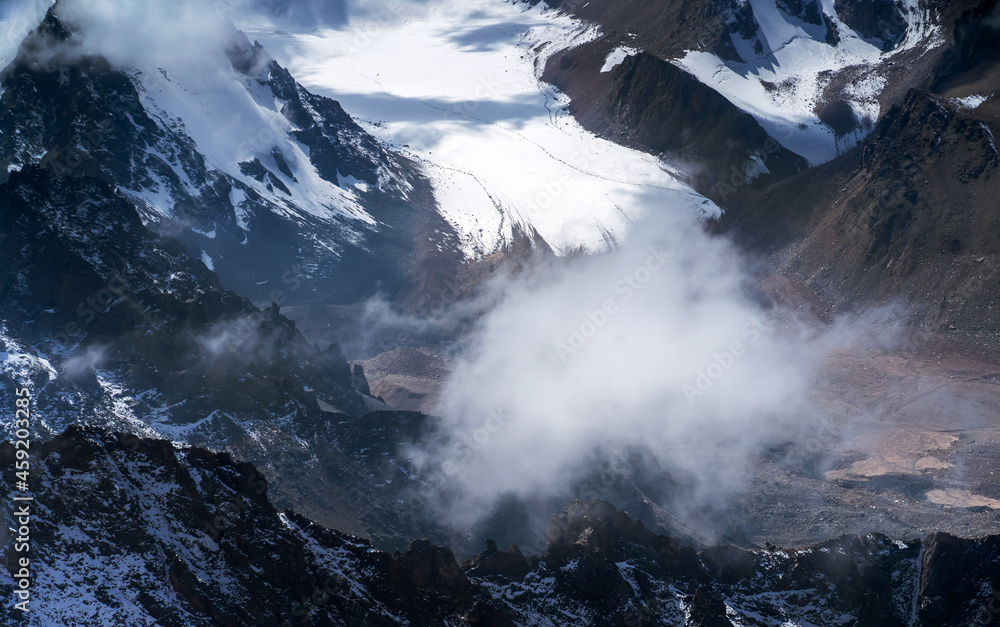 Obraz premium Rocks of the highlands, the road among the snow-capped peaks.