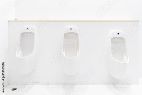 Modern and luxury male urinals on the white wall with electronic sensors for auto flushing