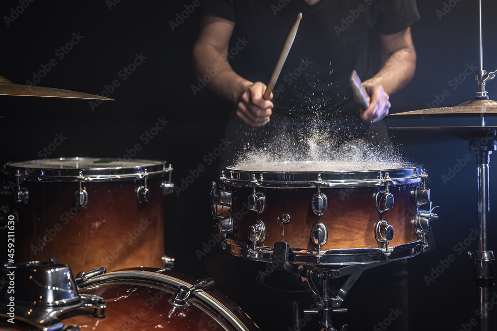 The drummer plays the snare drum with splashing water. - obrazy, fototapety, plakaty 