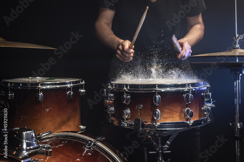 The drummer plays the snare drum with splashing water.