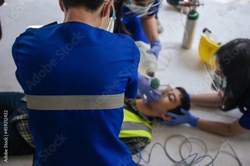 Selective focus, Paramedic man and team CPR and use ambu bag help unconscious worker accident in construction site.