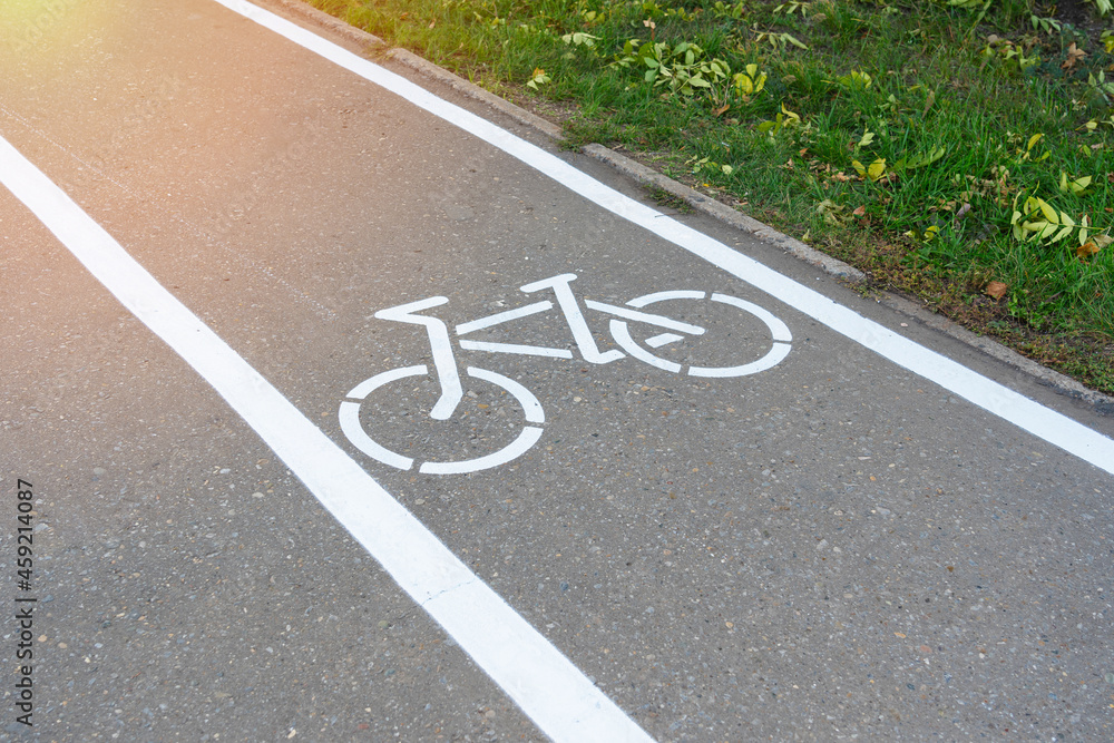 The road sign of the bike path . Drawing of a bicycle with white paint on the asphalt The road sign of the bike path . Drawing of a bicycle with white paint on the asphalt