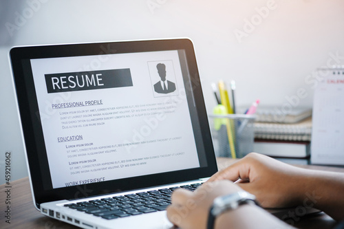 Man writing resume and CV in-home office with laptop. before send for new work and typing curriculum vitae for application. Job seeking, hunt, and unemployment