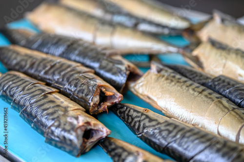 Pieces of smoked mackerel lie on a conveyor belt. Fish food factory.