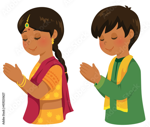 Hindu boy and girl in traditional Indian outfits praying during the Diwali festival.