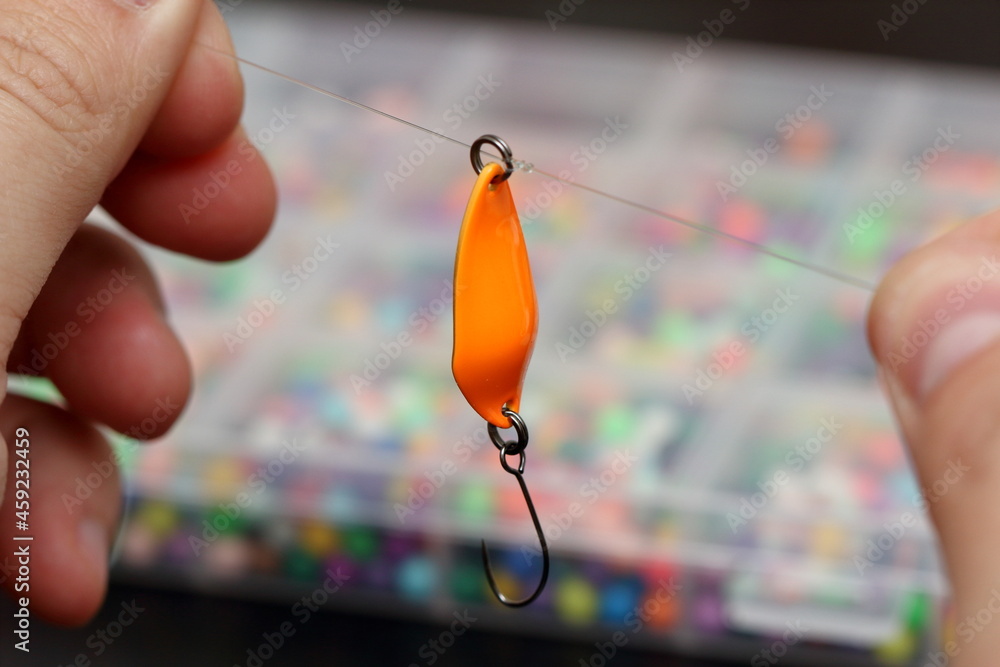 an orange fishing lure is tied to a fishing line an orange fishing lure is tied to a fishing line