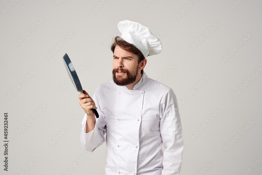 bearded man chef with a frying pan in hand light background bearded man chef with a frying pan in hand light background