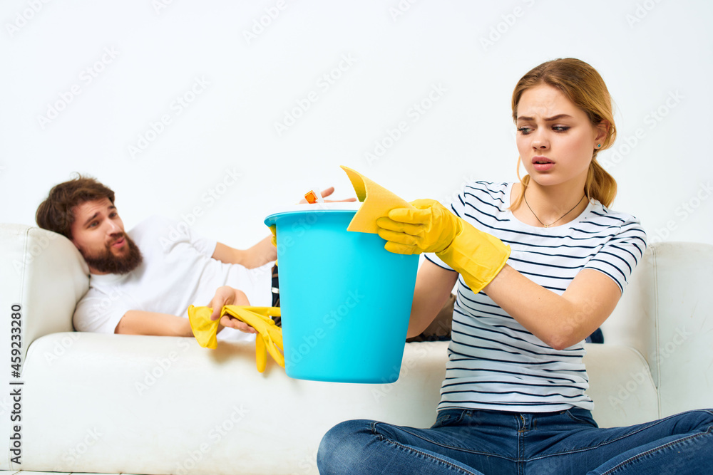 Man and woman near the sofa cleaning supplies provision of services Man and woman near the sofa cleaning supplies provision of services