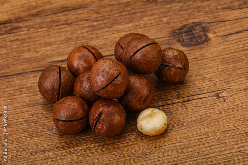 Brown macadamia nut heap over background Brown macadamia nut heap over background