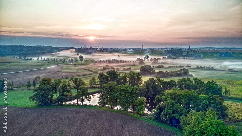 Fototapeta premium Landschaft im Nebel bei aufgehender Sonne