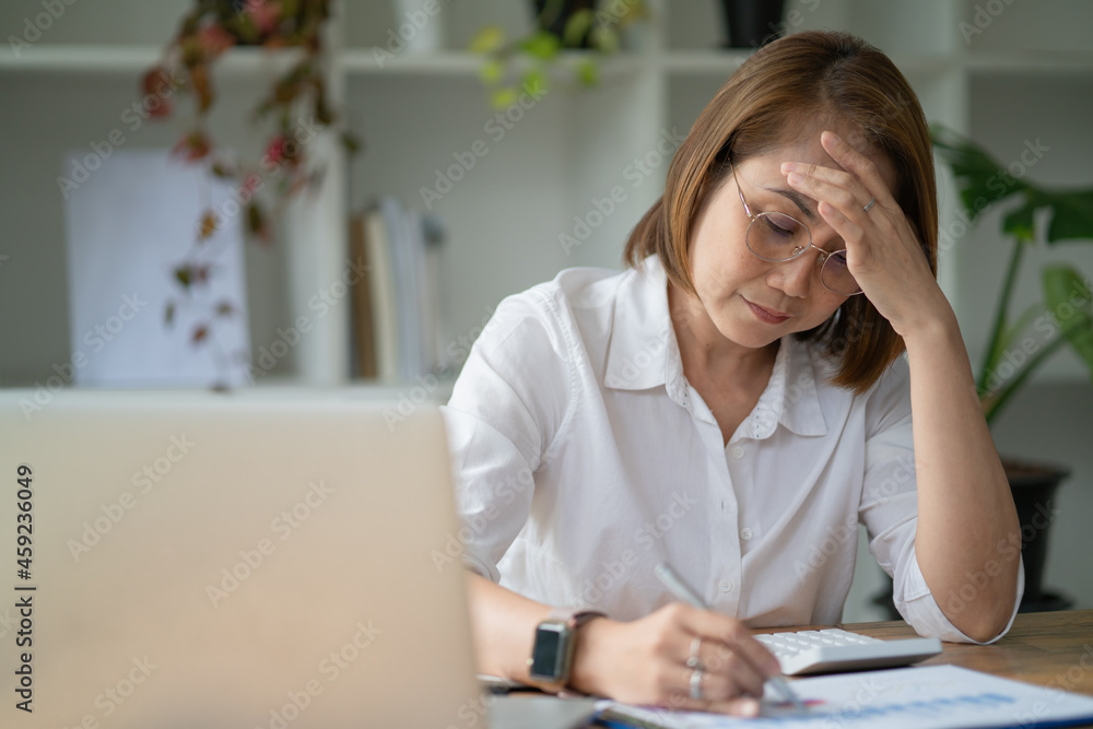 Asian businesswoman gets stressed while having a problem at work in the office Asian businesswoman gets stressed while having a problem at work in the office