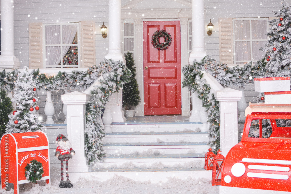 Snowy courtyard with Christmas porch, veranda, wreath, Christmas tree, red car, gnome, letterbox for Santa Claus, lanterns, garland. Merry Christmas and Happy New Year