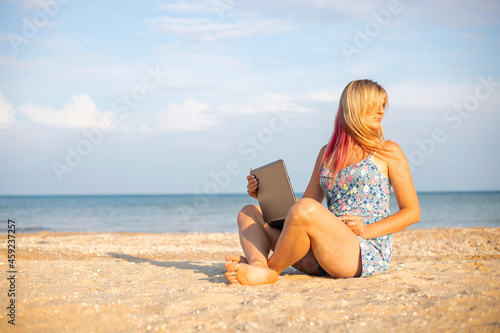 Beautiful young woman working with laptop on the tropical beach. Successful person concept © spyrakot