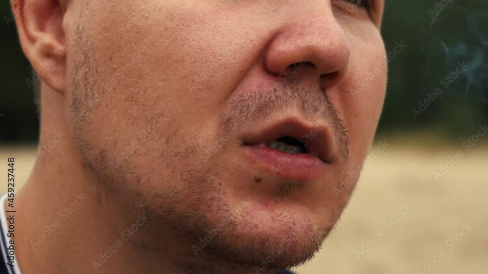 man smoking cigarettes standing on the beach close up man smoking cigarettes standing on the beach close up