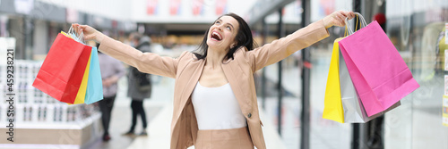 Happy joyful woman with purchases in mall closeup