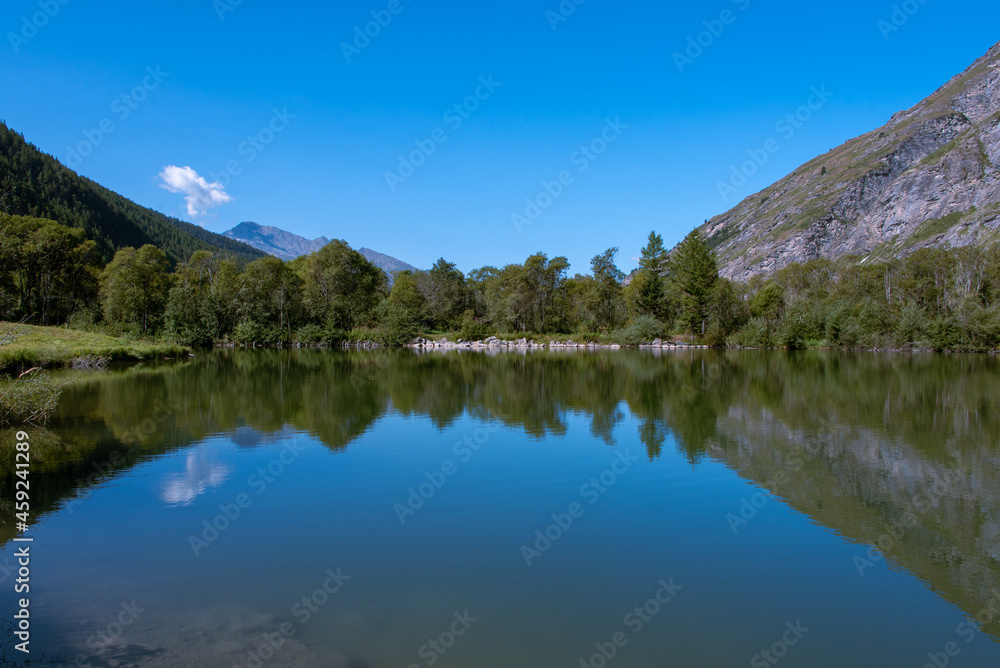 the sky reflecting in the waters of the lake of Bessans in Haute Maurienne in the French Alps