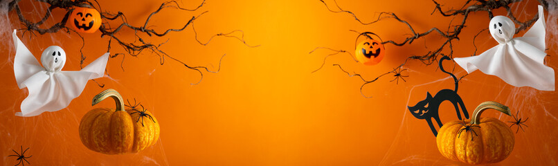 Halloween ghosts with funny pumpkin on orange background. Happy halloween holiday concept. Handmade decoration for festival party.