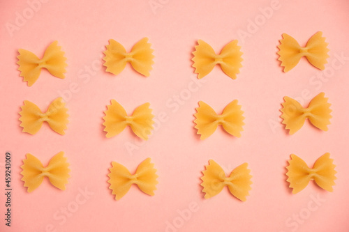 Trendy flat view closeup yellow macaroni. Farfalle. Top view, flat lay. Nature concept. Texture background, pattern. Restaurant work concept. Ready for print, copy space.