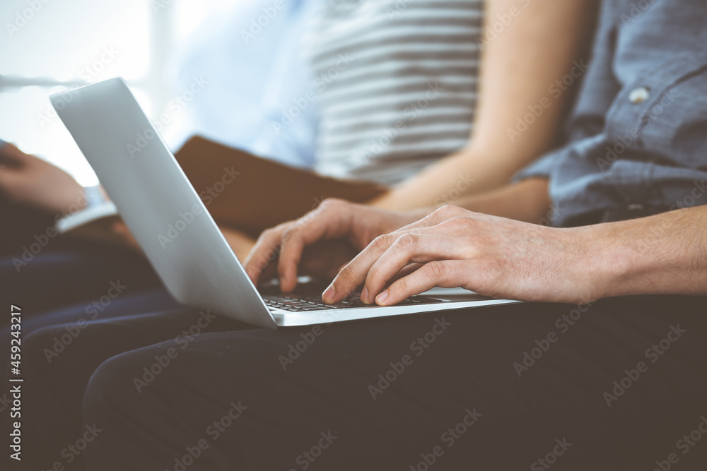 Group of casual dressed business people working at meeting or conference, close-up of hands. Businessman using laptop computer. Teamwork or coaching concept Group of casual dressed business people working at meeting or conference, close-up of hands. Businessman using laptop computer. Teamwork or coaching concept