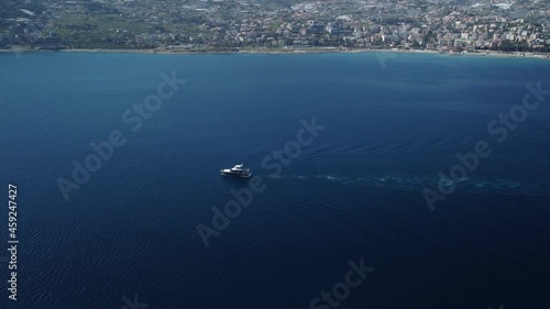 Ripresa con Drone di Imbarcazione che naviga parallelamente alla costa mentre si dirige verso il Sole