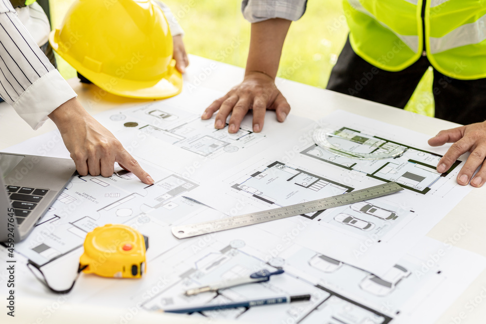 Two architect-engineers are consulting to modify the blueprints of the contracted house, they have a meeting to inspect the house designs before meeting with the client. Home design ideas. Two architect-engineers are consulting to modify the blueprints of the contracted house, they have a meeting to inspect the house designs before meeting with the client. Home design ideas.