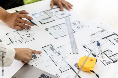 Two architect-engineers are consulting to modify the blueprints of the contracted house, they have a meeting to inspect the house designs before meeting with the client. Home design ideas.