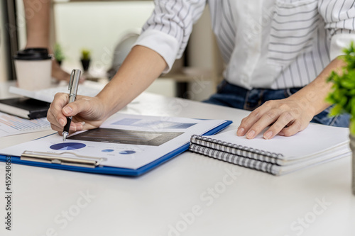 Business woman are looking at the company's financial documents to analyze problems and find solutions before bringing the information to a meeting with a partner. Financial concept.